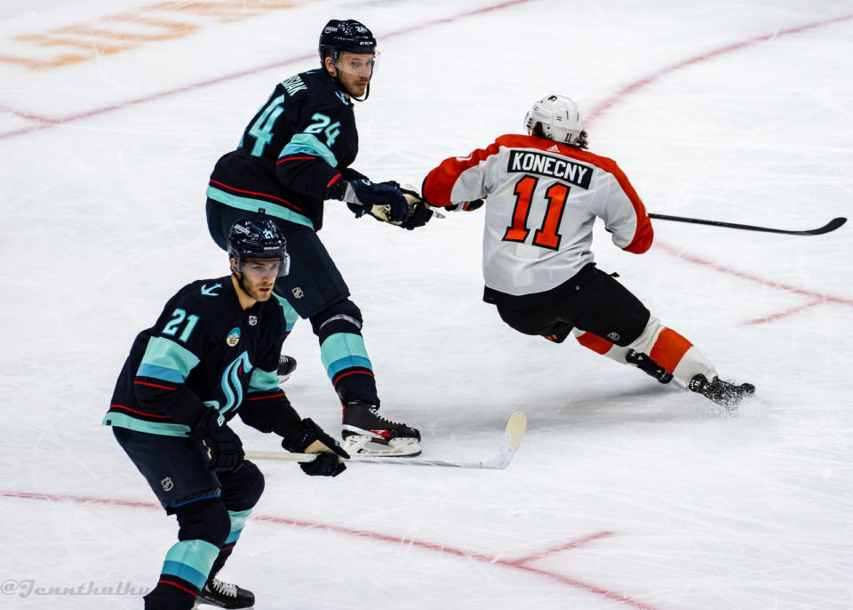 Travis Konecny of the Flyers battles Seattle's Jamie Oleksiak and Alexander Wennberg in December 2023